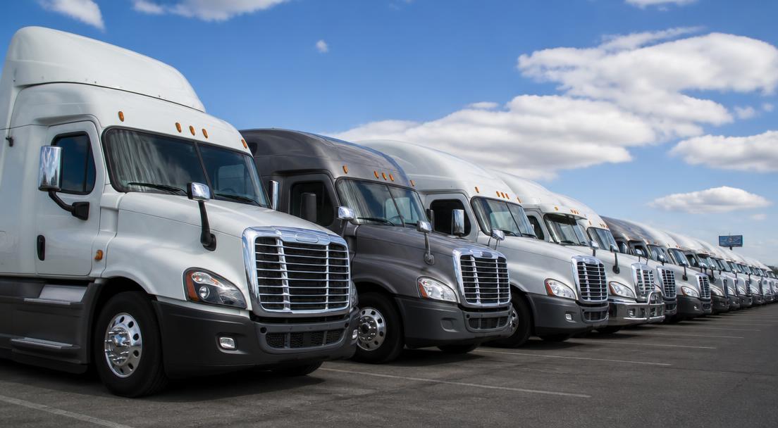 Fleet of semi trucks parked in a row